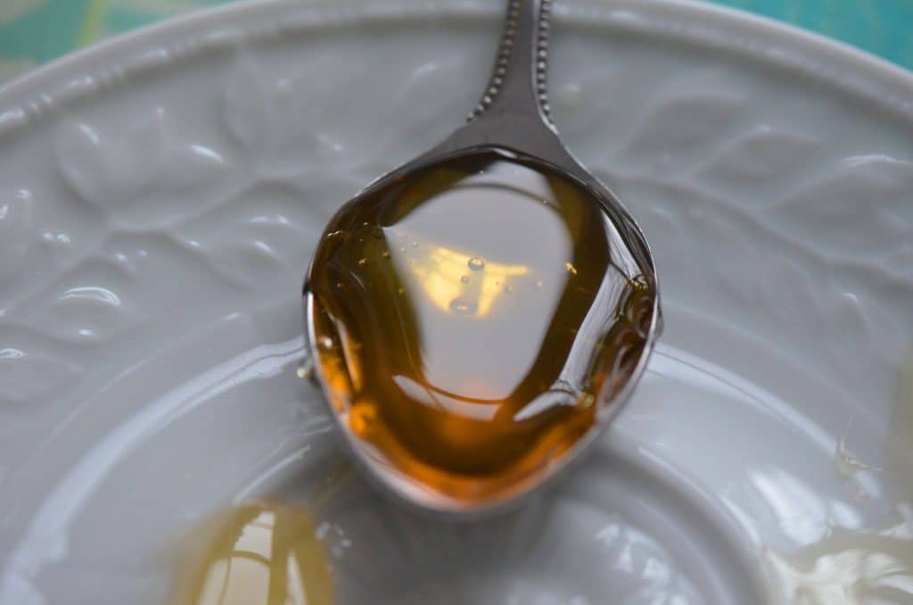 Honey on a spoon on a white plate