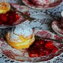 Cream puff with strawberries on a pink and white vintage plate