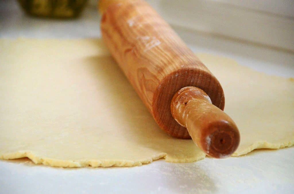 Wooden rolling pin with pie dough