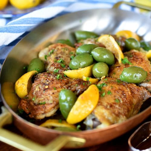 Chicken with lemon and olives in a copper baking dish