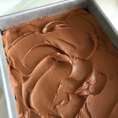 Chocolate buttercream swirls over brownies.