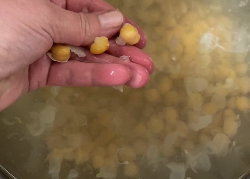 Remove chickpea skins by hand in a bowl of water
