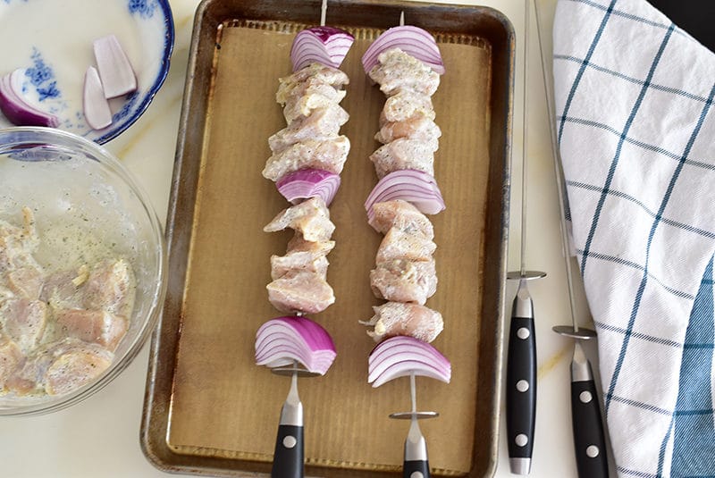 Marinated chicken and red onion threaded on skewers, ready for the grill!