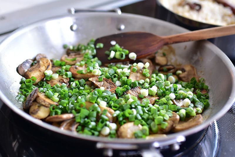 Sauteed mushrooms and scallions in a saute pan