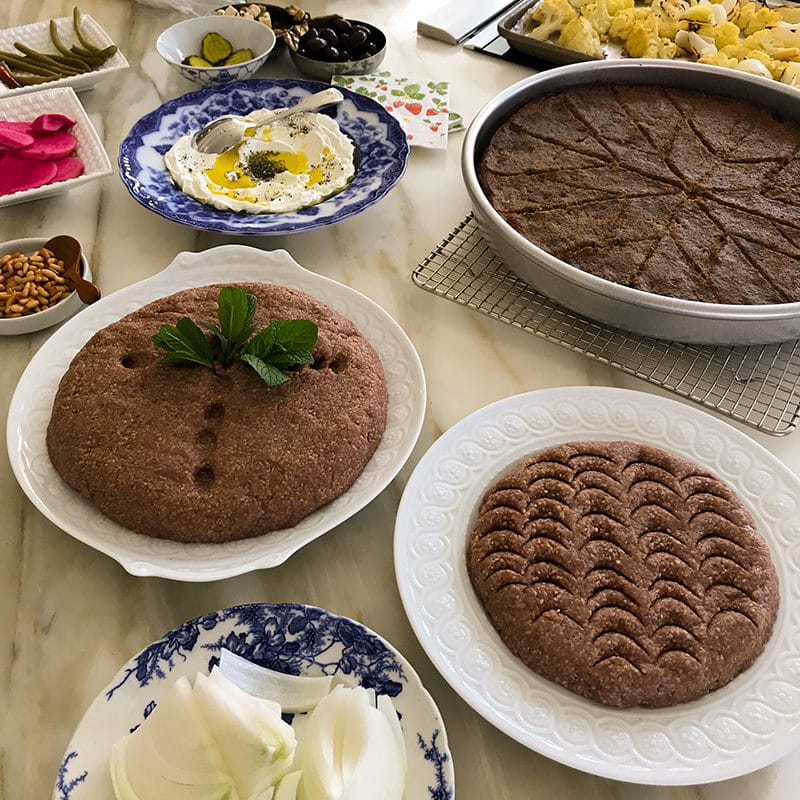 Lebanese kibbeh, raw and baked, with condiments on the kitchen counter