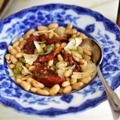 White beans with za'atar roasted tomatoes and olive oil, in a vintage blue pasta bowl