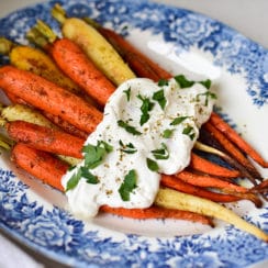 Za'atar roasted carrots with labneh on a blue floral platter
