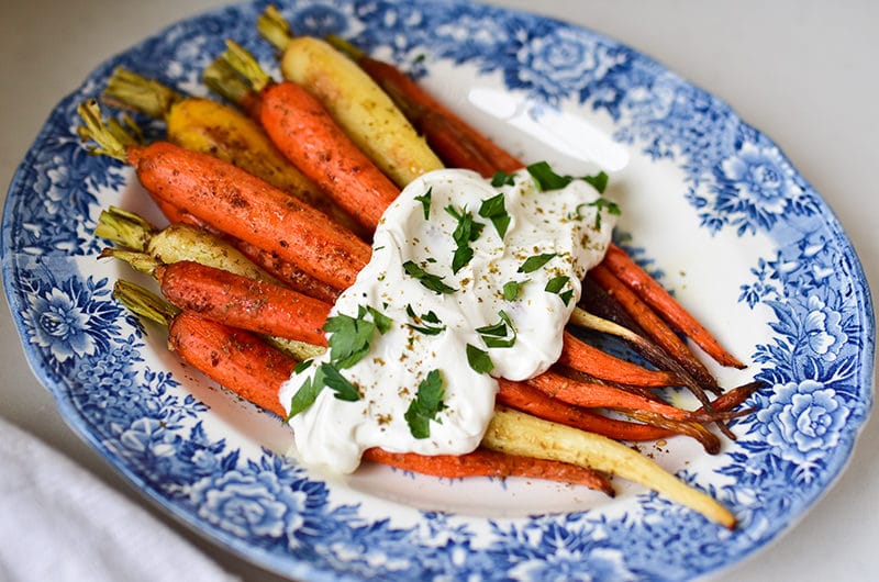 Za'atar roasted carrots with labneh on a blue floral platter