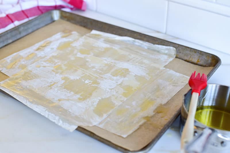 Phyllo layers buttered on a sheetpan
