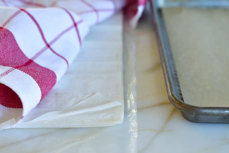 Phyllo dough sheets under a dishtowel