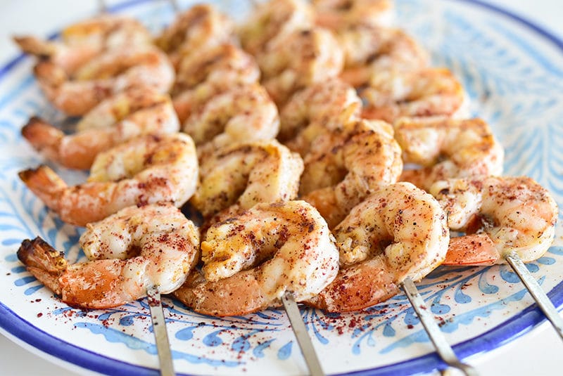 Garlicky Sumac Shrimp skewers on a blue plate