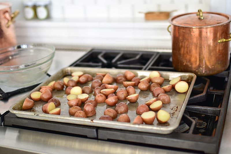 New potatoes on a sheet pan with a copper pot