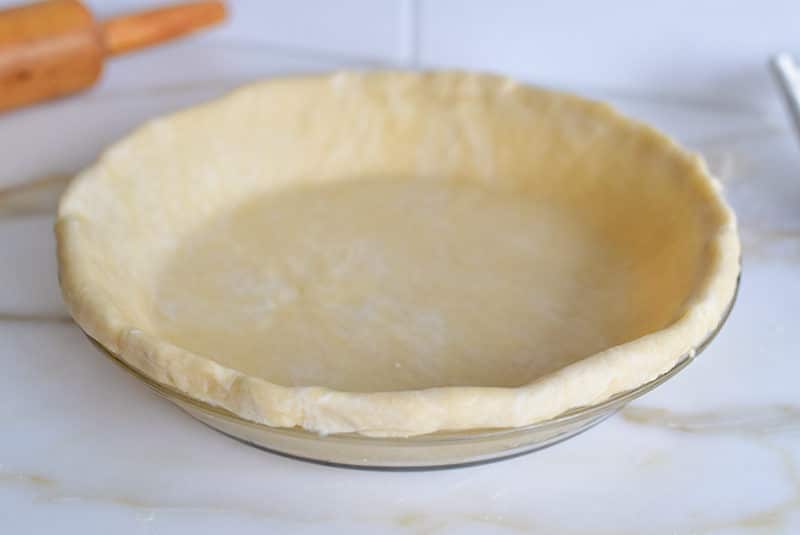 Pie dough in plate ready to be crimped