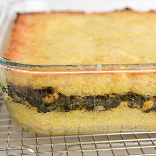 Potatoes layered with spinach in a glass dish