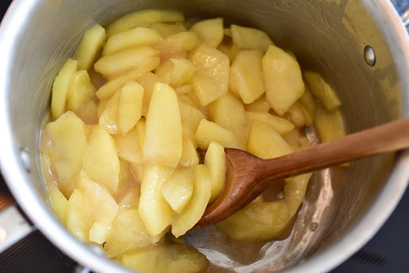 Apples with wooden spoon in a saucepan