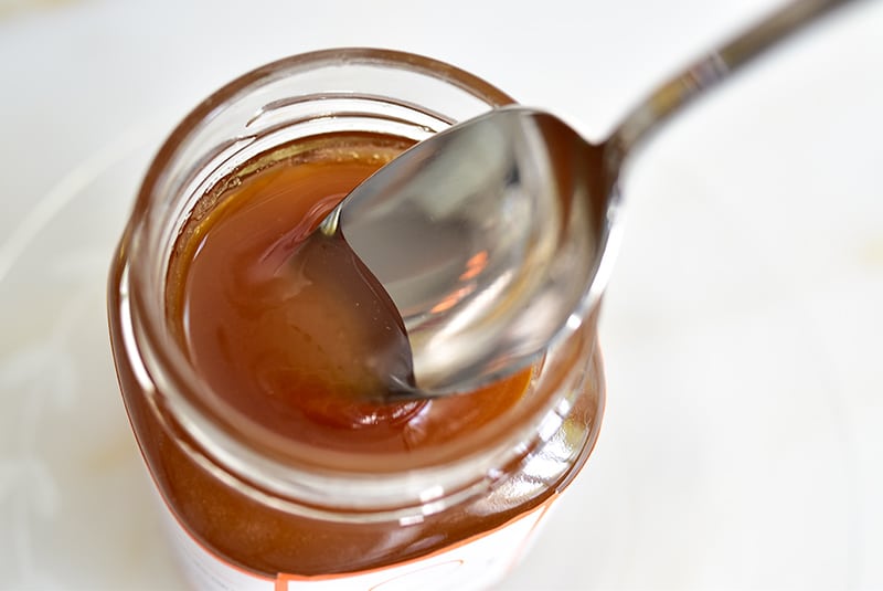 Spoon dipped into a honey jar