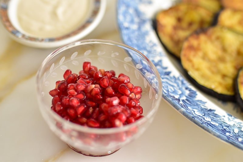 Red pomegranate seeds in a clear bowl