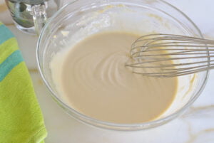 Tahini sauce in a bowl with a whisk
