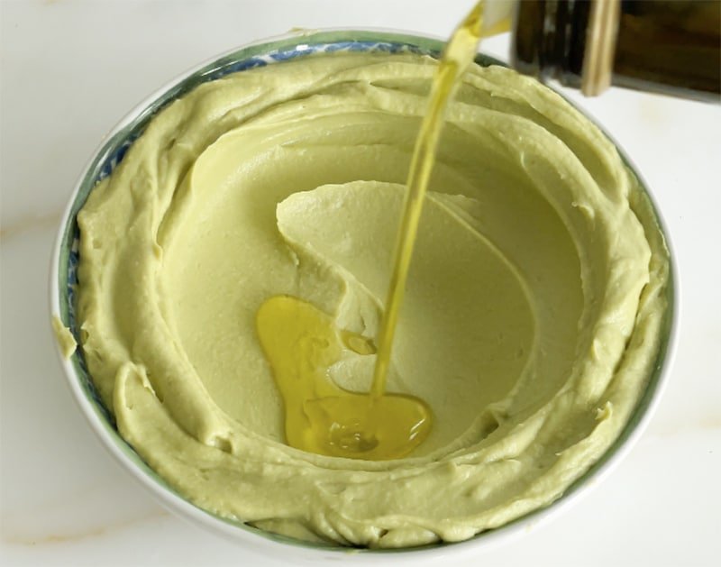 Olive oil drizzled over avocado hummus