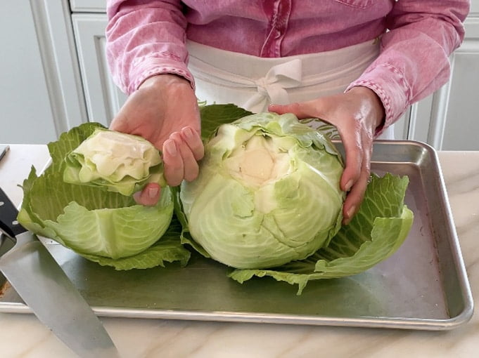 Head of cabbage with hands holding the core cut out