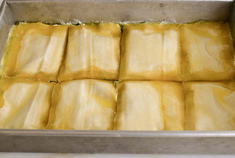 buttered phyllo for spanakopita in a pan