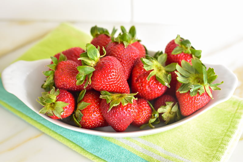 Bowl of strawberries on a green towel