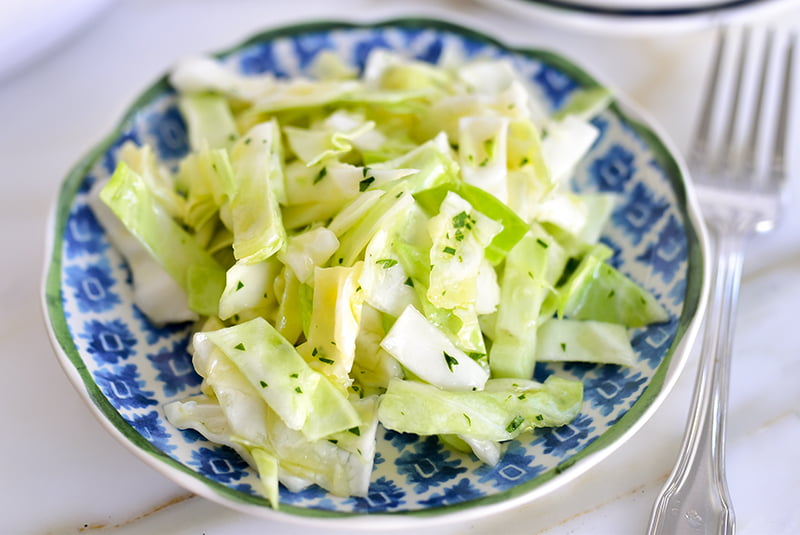 Cabbage salad with garlic and lemon on a blue plate