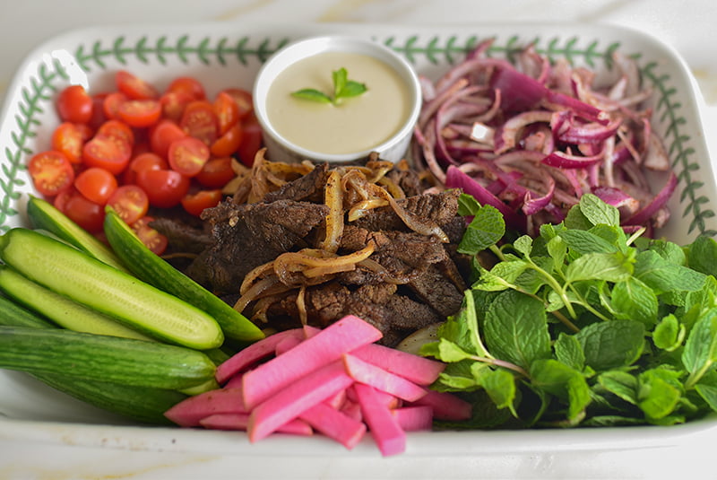 Beef shawarma platter with tahini sauce and vegetables