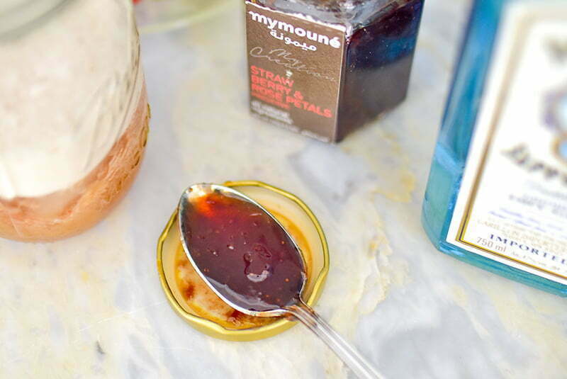 Strawberry jam in a spoon for gin cocktail on the counter