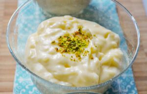 Rice pudding with pistachios on top in a bowl